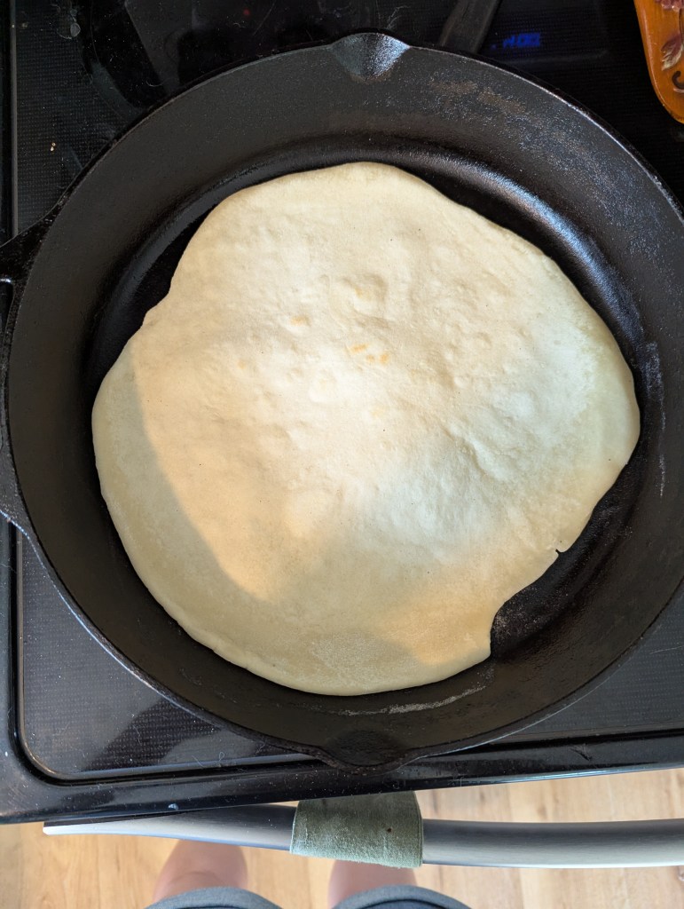 Cooking sourdough tortillas recipe in cast-iron skillet