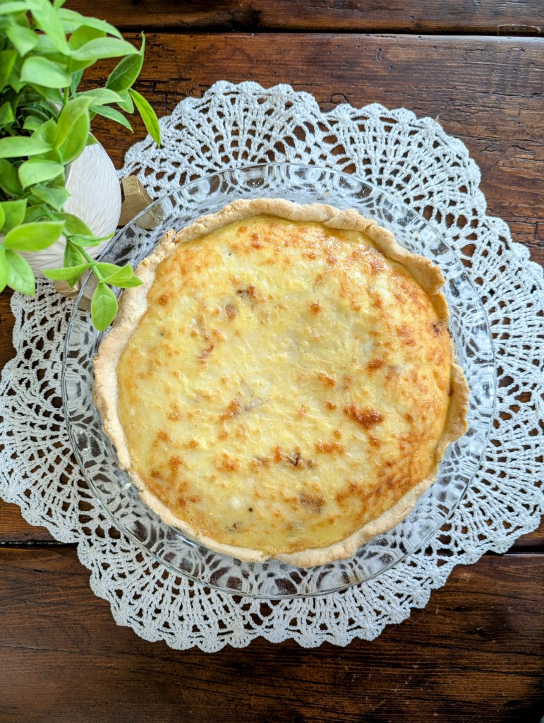 Freshly baked high-protein quiche Lorraine cooling on a farmhouse table