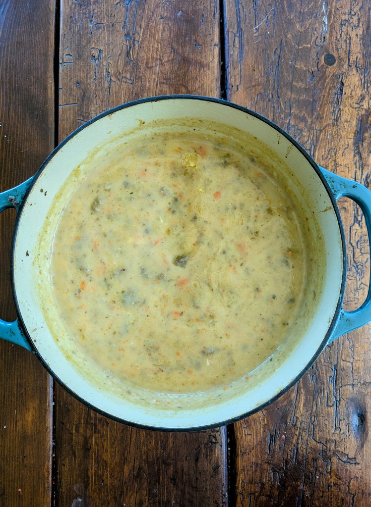 healthy potato soup in a Dutch oven on wooden farmhouse table