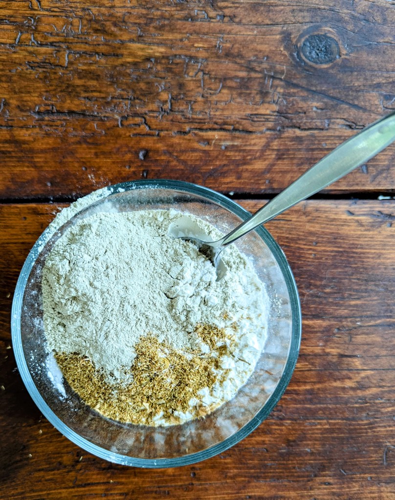 Mixing arrowroot powder and dried flowers to make DIY baby powder at home
