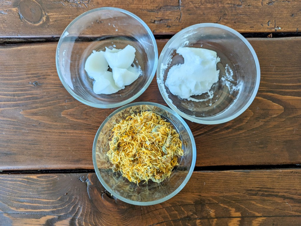 Ingredients for homemade calendula oil includeing coconut oil and tallow
