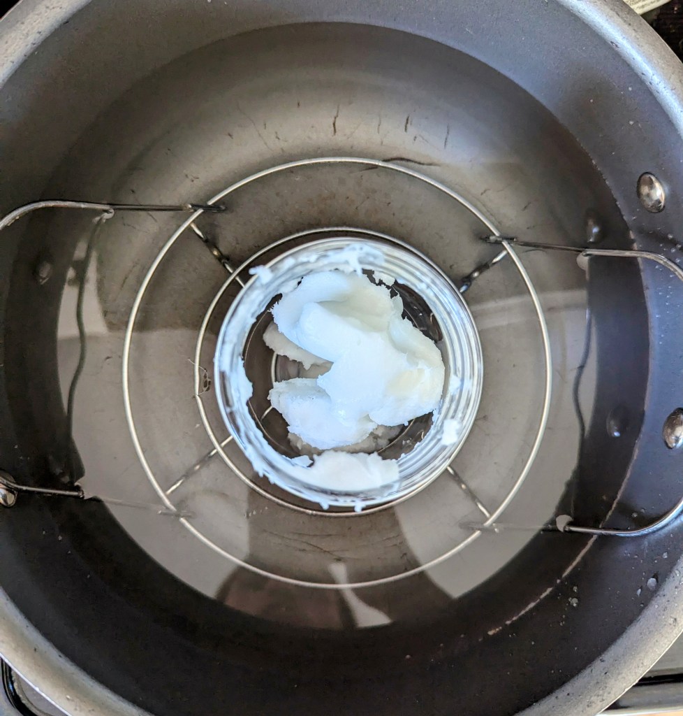 Melting coconut oil and beef tallow for calendula oil infusion