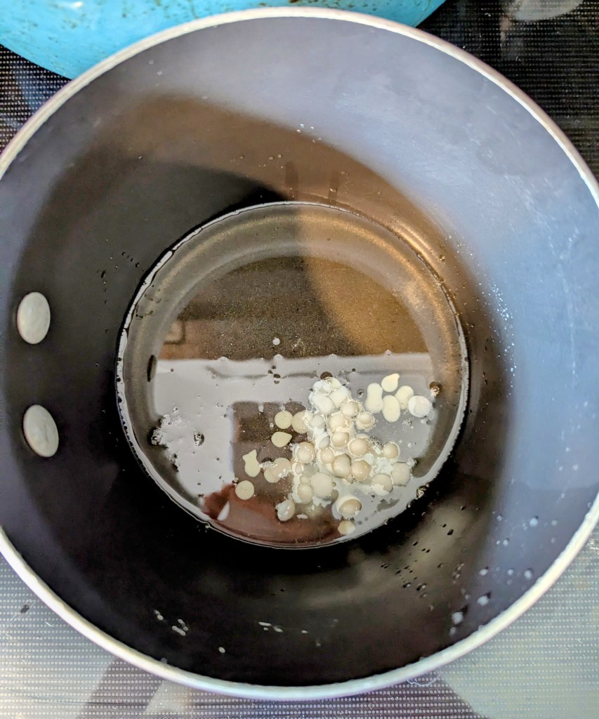 Melting coconut oil and beeswax pellets for DIY diaper cream