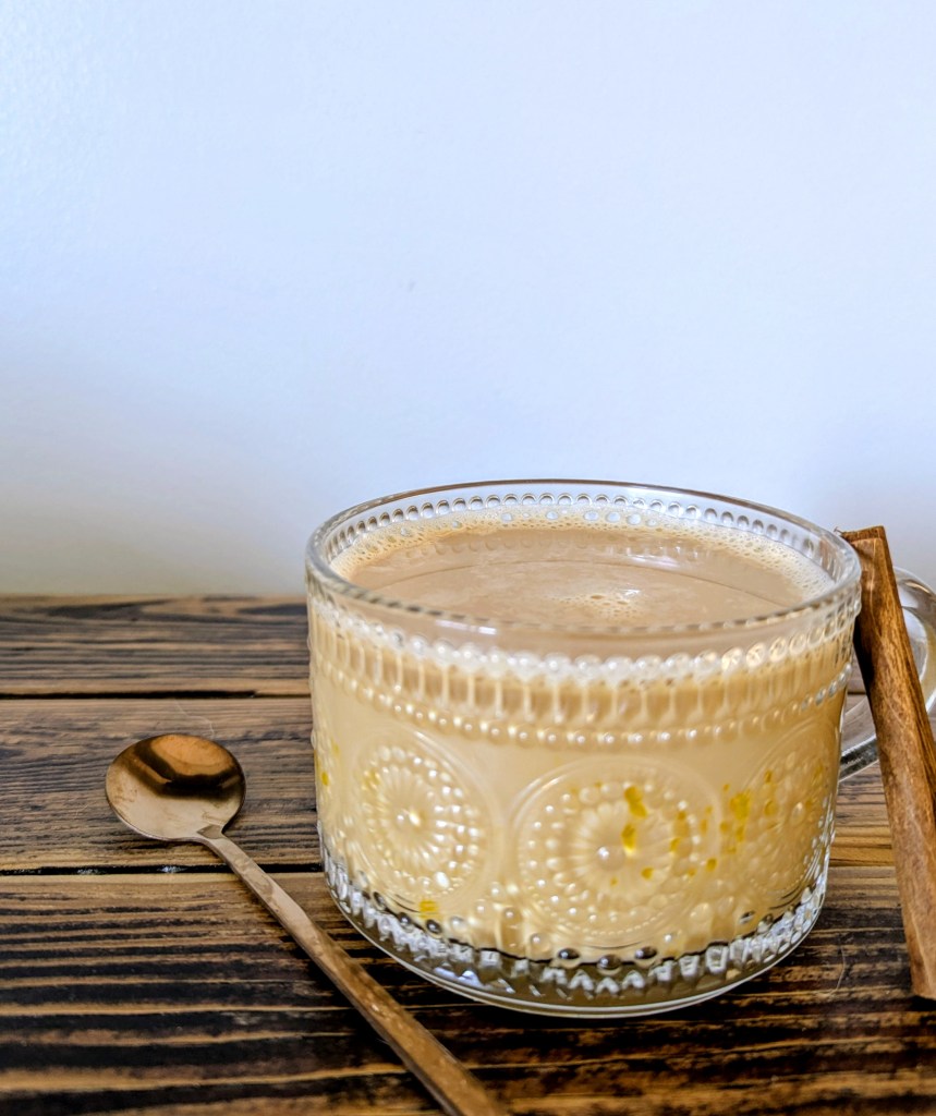 Healthy lattee with egg yolk and collagen on wooden farmhouse table