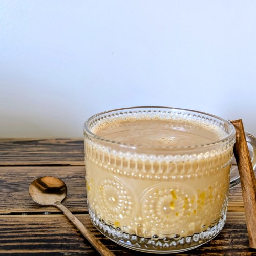 Healthy latte with egg yolk and collagen on wooden farmhouse table