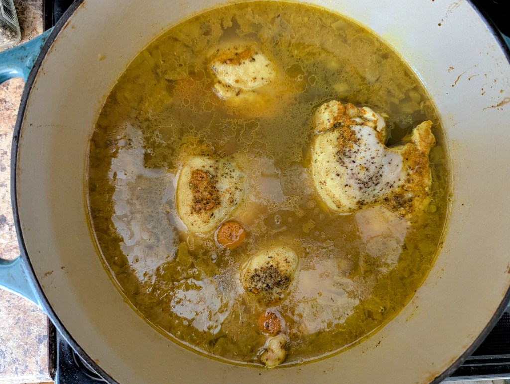 simmering healthy chicken soup in a dutch oven
