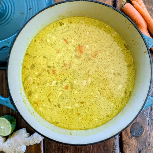 Healthy chicken soup with ginger and carrots on farmhouse table