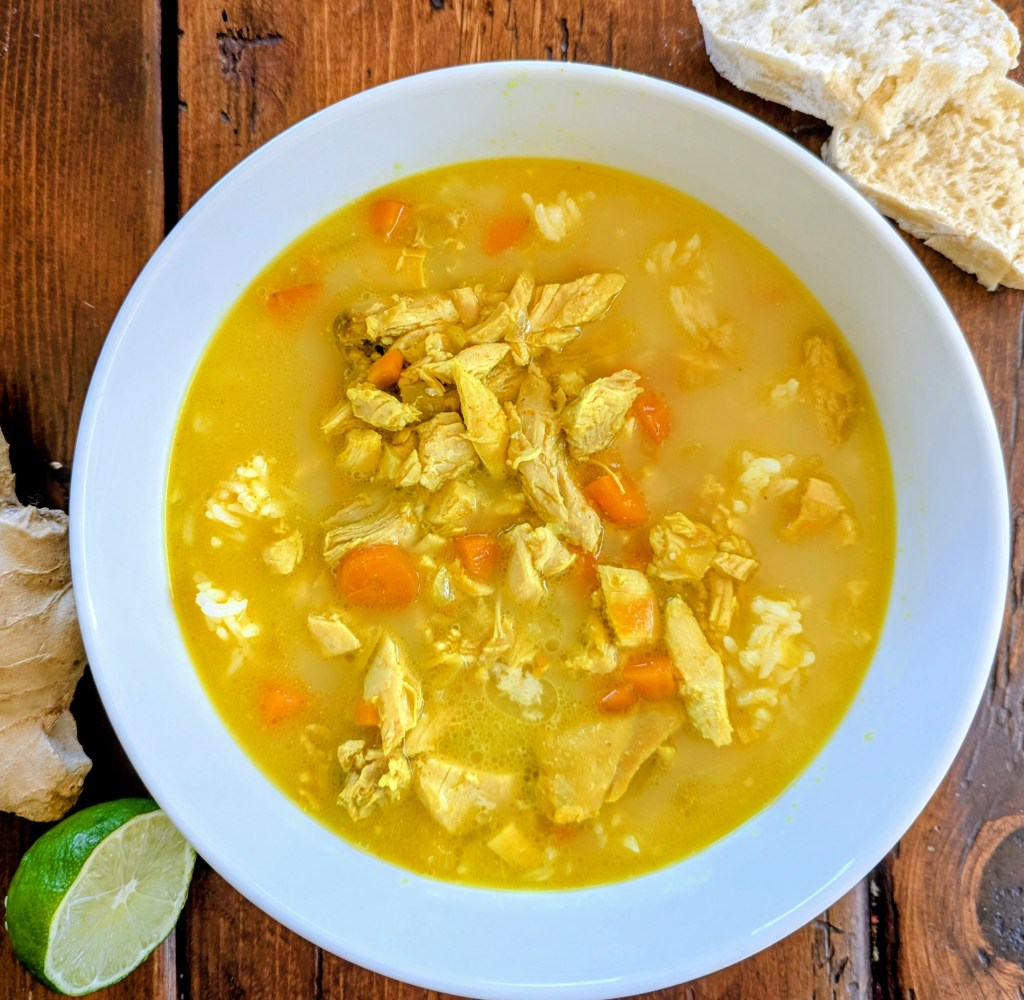 Bowl of healthy chicken soup with ginger and fresh bread
