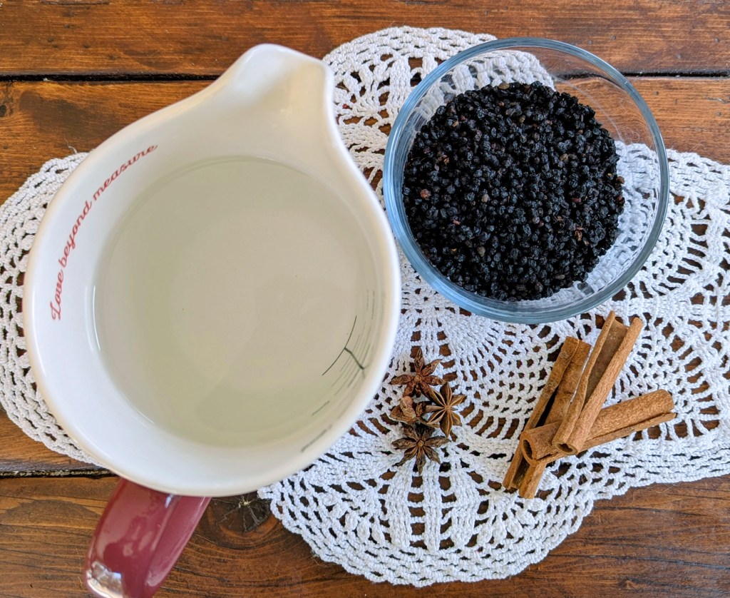 Ingredients for an elderberry syrup recipe on a farmhouse table