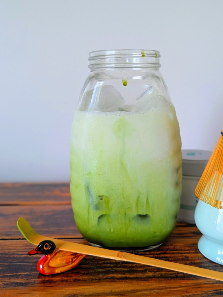 Lavender matcha on a wooden farmhouse table with a stir stick