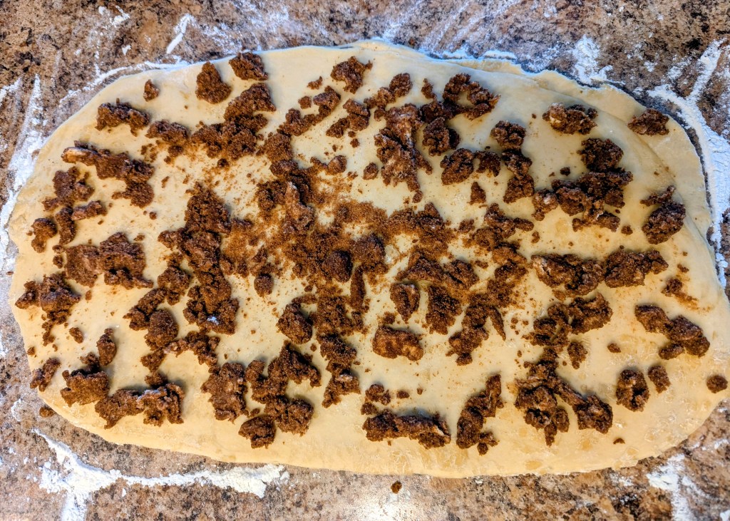 Spreading cinnamon sugar filling on sourdough cinnamon roll dough