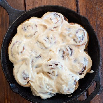 Iced sourdough cinnamon rolls on a farmhouse table