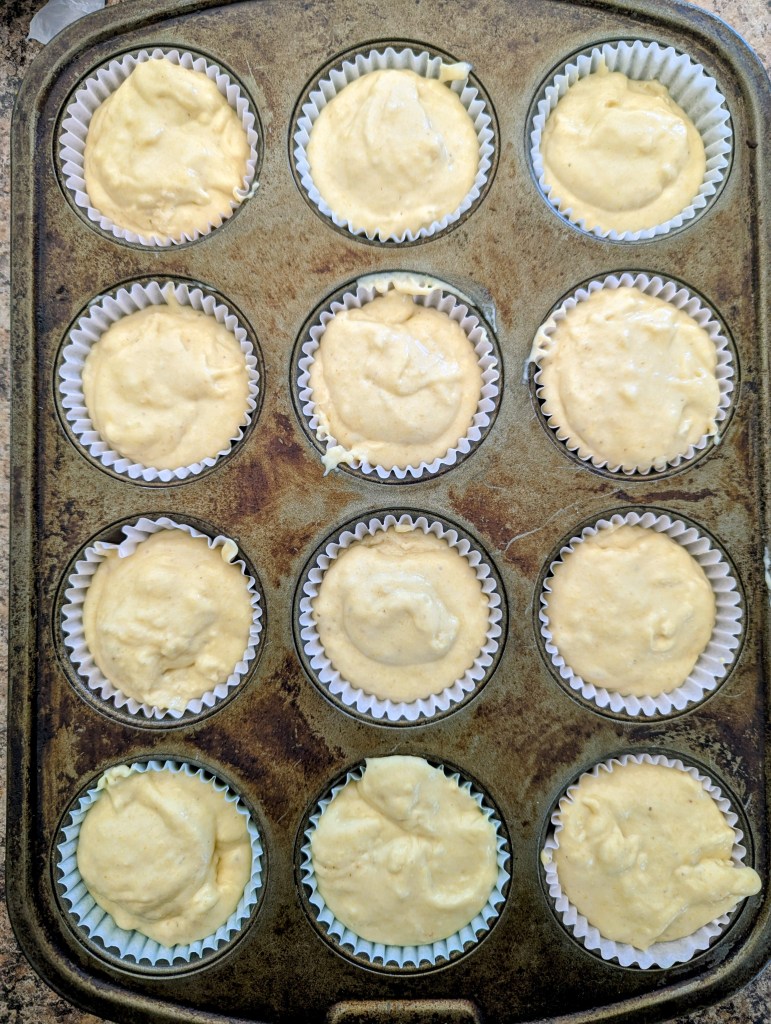 Sourdough cornbread batter in muffin tins before baking