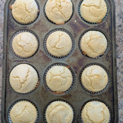 Golden sourdough cornbread muffins in a muffin tin