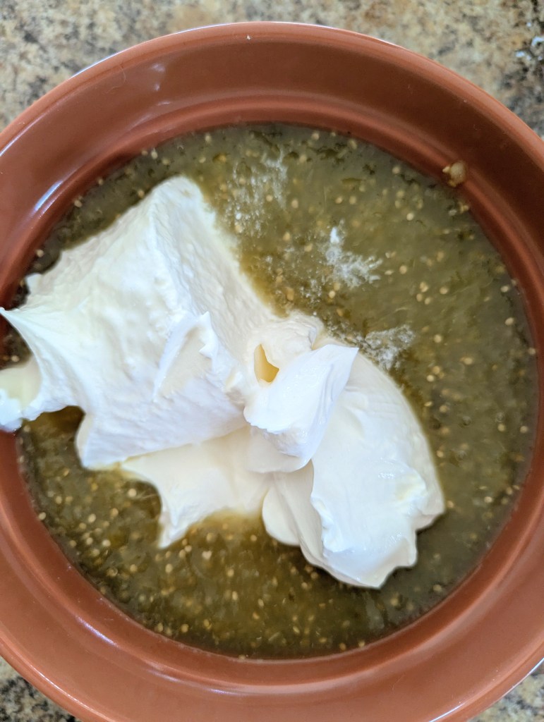 Boel of sour cream and salsa verde before mixing