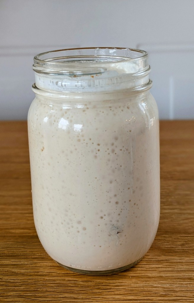 bubbly sourdough starter in a glass jar