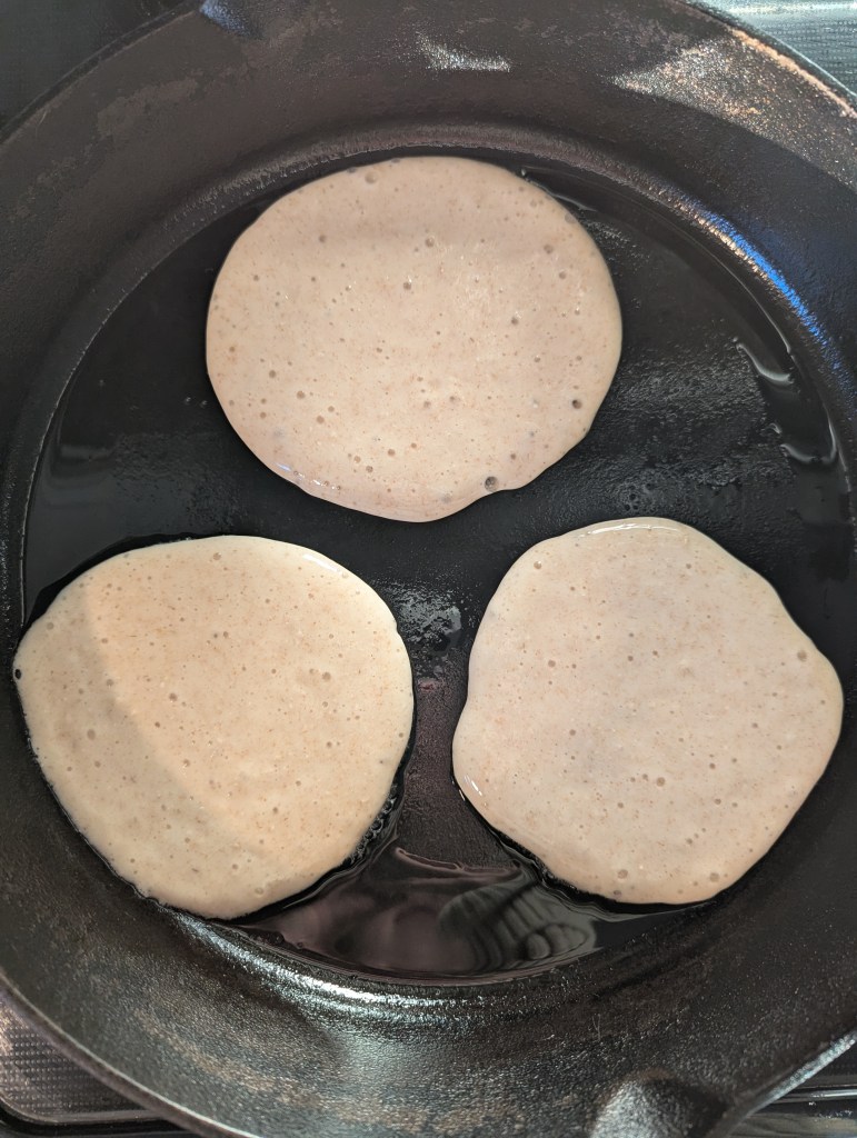 Banana cottage cheese pancakes in a cast-iron skillet