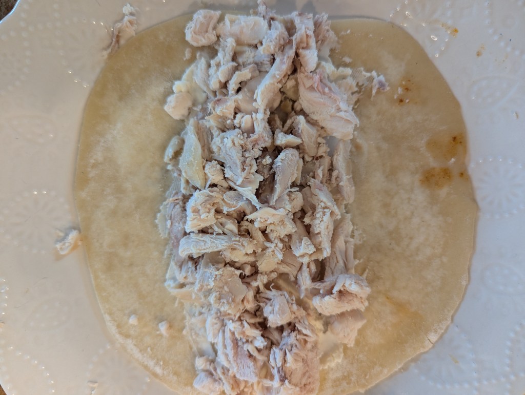 Filling tortillas for chicken enchiladas with cream cheese