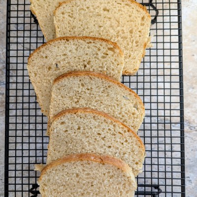 Sliced sourdough sandwich bread on a cooling rack