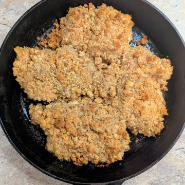 Aerial shot of oven fried chicen thighs in a cast iron skillet