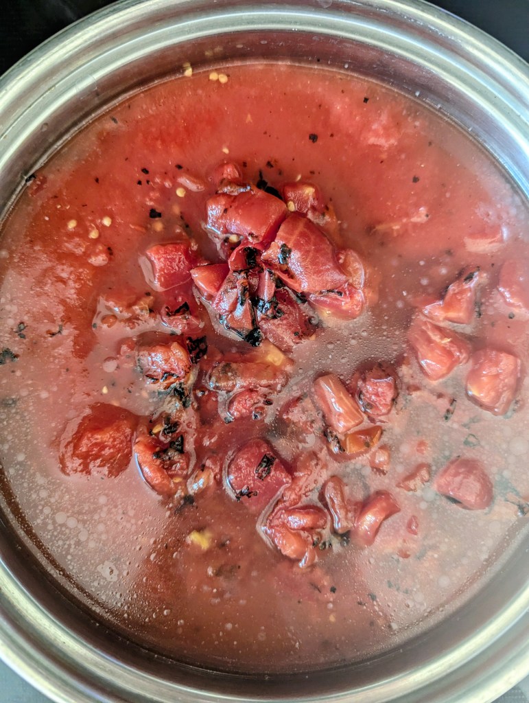 Simmering ingredients for tomato soup from canned tomatoes