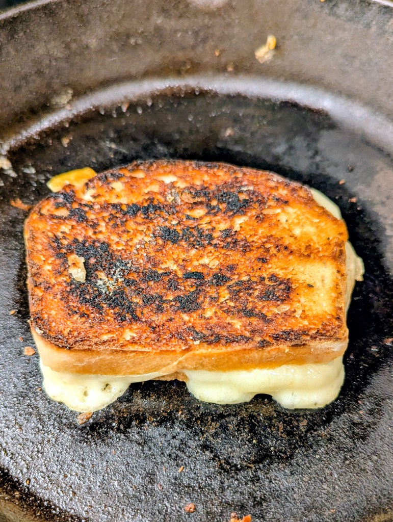 Golden sourdough grilled cheese in a cast-iron skillet