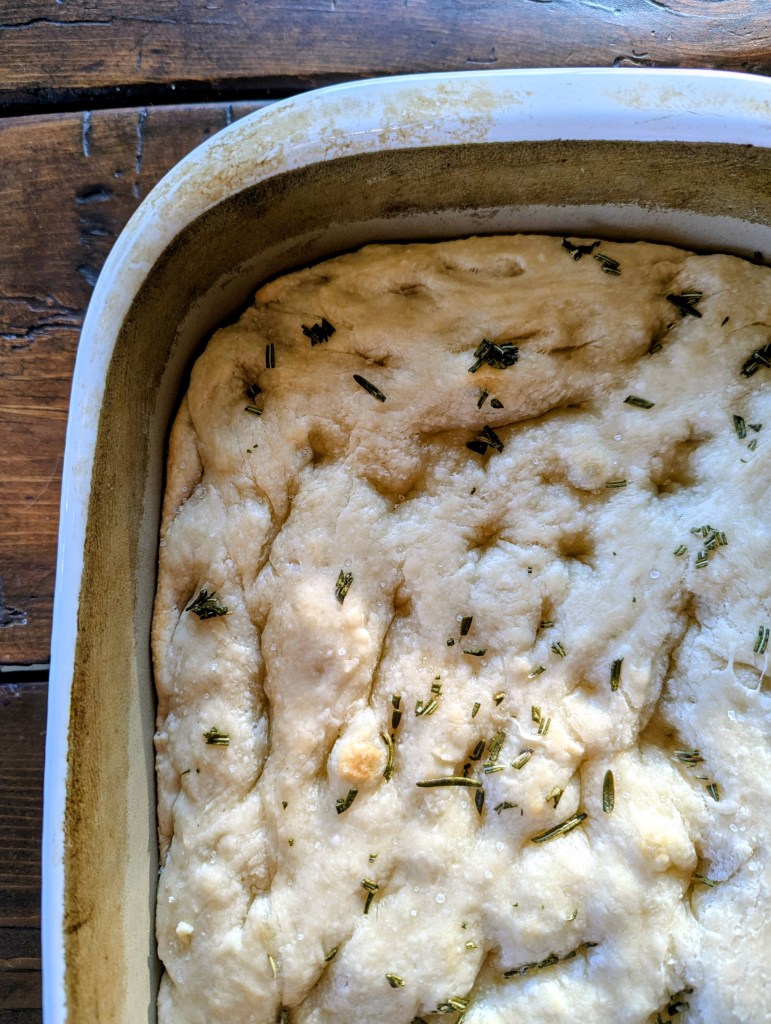 Golden sourdough focaccia on a farmhouse table