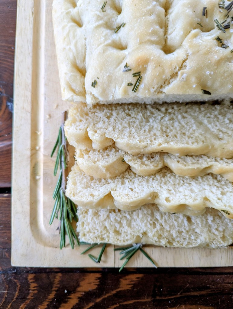 Sliced sourdough discard focaccia on a wooden table