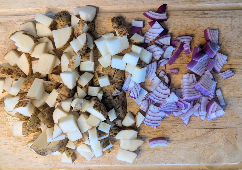Aerial shot of sliced potatoes and onions for kielbasa and potatoes