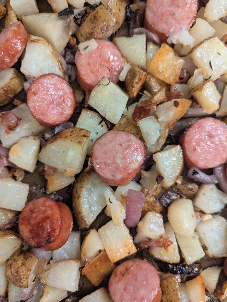 Close up of kielbasa and potatoes on a sheetpan