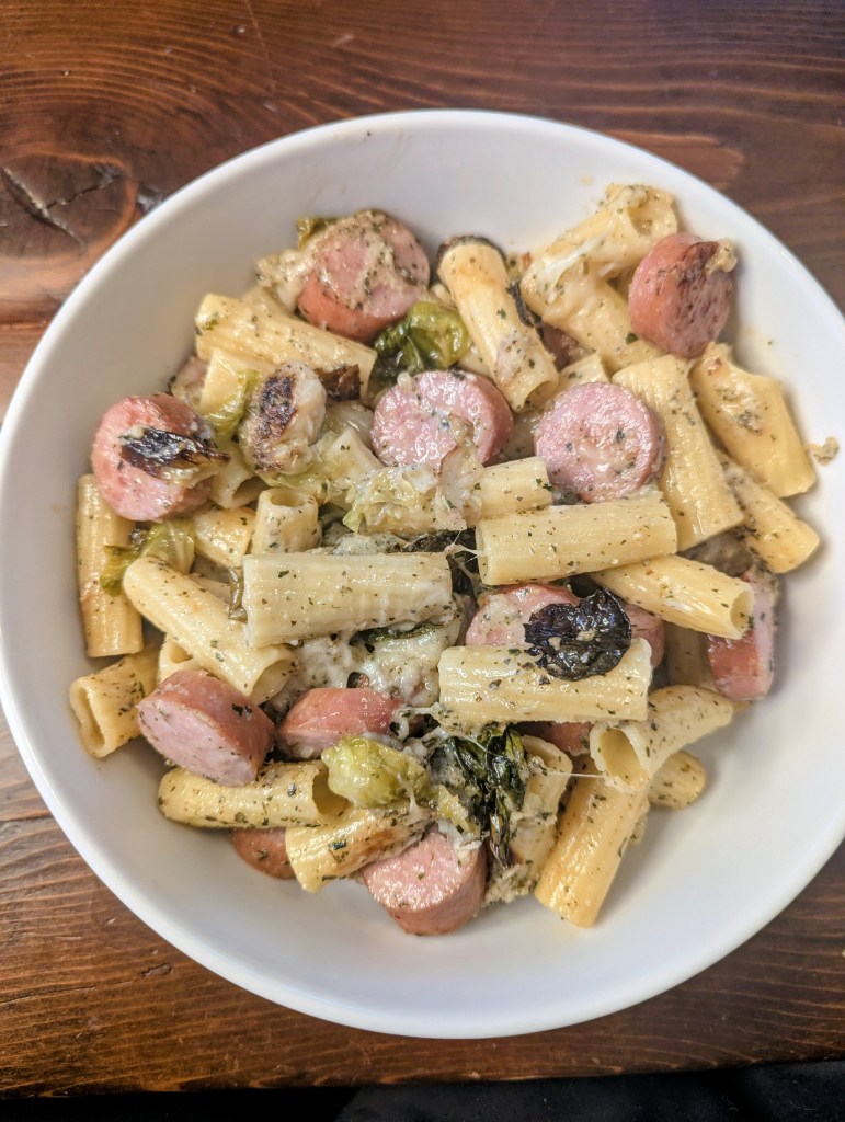Kielbasa pasta with brussel sprouts on a farmhouse table