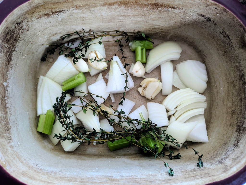Chopped veggies in a roasting pan for cornish game hen recipe