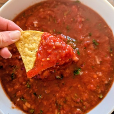 Dipping a chip into homemade salsa with canned tomatoes