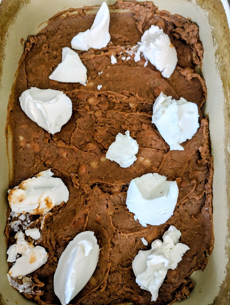 Dolloping cream cheese into a raco casserole