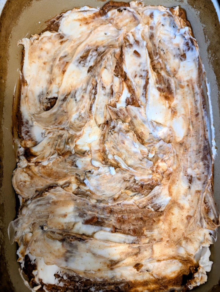 Spreading cream cheese in taco casserole recipe