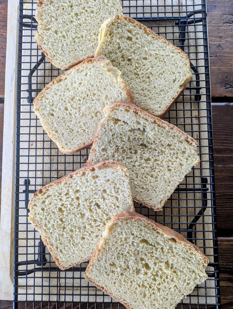 Sliced sourdough sandwich bread on a wire rack